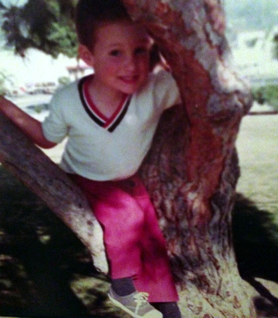 Mike Millett as a young boy, sitting in a tree