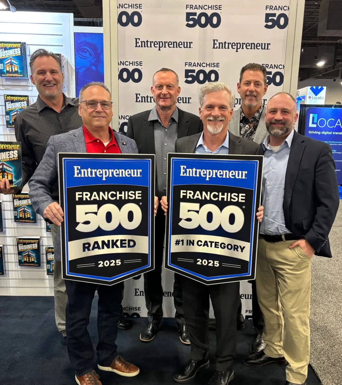 Six men at the Entrepreneur Franchise 500 backdrop holding two 2025 plaques, Ranked and #1 in Category. From left: Mike Millett, David Earl, Stuart Erskine, Doug Flaig, Rob Lancit and Jotham Hatch